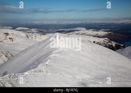 Guardando ad est verso il basso il bordo Swirral dalla vetta della montagna Helvellyn nel Parco nazionale del Lake District in Cumbria, Inghilterra durante l'inverno. Neve. Foto Stock