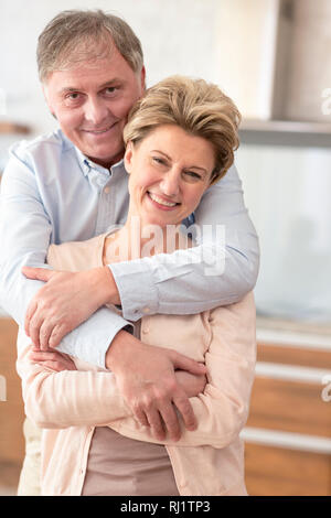 Ritratto felice coppia matura in piedi a casa Foto Stock