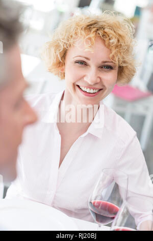 Ritratto di sorridente coppia donna seduta con l uomo al tavolo nel ristorante Foto Stock