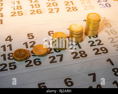 Immagine della moneta in euro di pile sulla calandra indicante il giorno di paga Foto Stock