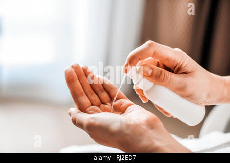 Una donna mette sulle mani di cosmetici da un flacone di liquido o sapone naturale. Cura del corpo concetto Foto Stock