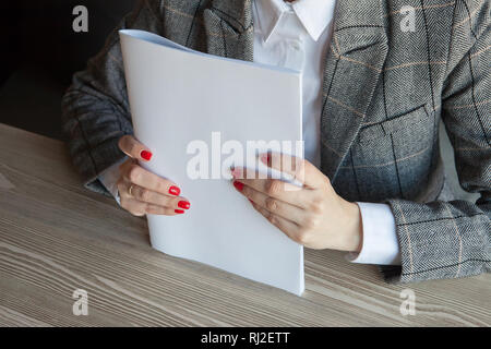 La ragazza tiene in mano il modello magazzino formato A4 Foto Stock