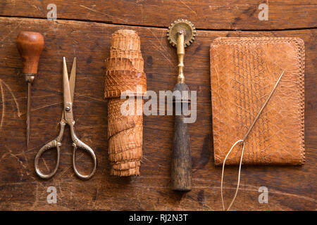 Artigianali in pelle strumenti su un sfondo di legno Foto Stock