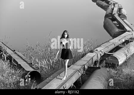 La donna a piedi su metallo pontoon ponte sul fiume Foto Stock