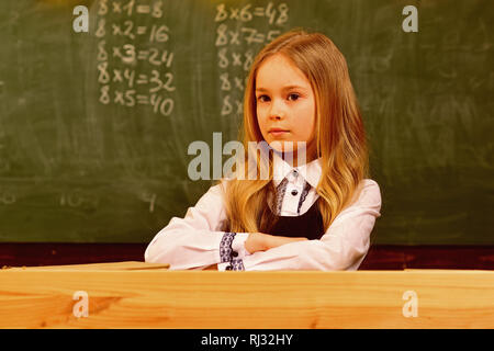 Piccola ragazza. piccola ragazza con gravi faccia nella scuola. piccola ragazza a scuola lezione. piccola ragazza è pronta a studiare. piccolo felice kid. Foto Stock