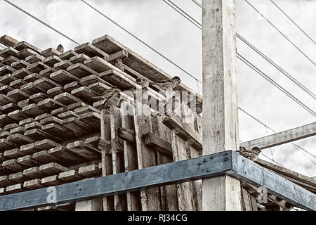 Un gregge di passeri seduta su pallet contro il cielo e i fili in stile grunge Foto Stock