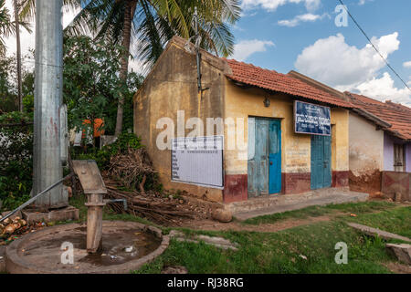 Belavadi, Karnataka, India - 2 Novembre 2013: Il governo sponsorizzato comunale pompa acqua del villaggio con bordo bianco pianificazione agricola sche Foto Stock