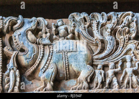 Halebidu, Karnataka, India - 2 Novembre 2013: Hoysaleswara tempio di Shiva. Primo piano di un elefante e il gruppo di statue di uomini sul lato del tempio una struct Foto Stock