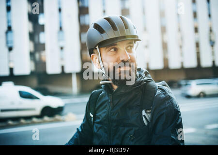 Corriere maschio con noleggio casco la consegna dei pacchi in città. Foto Stock