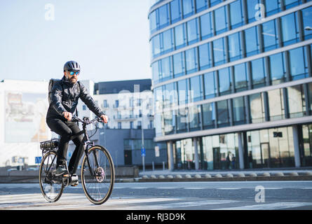 Un maschio di bicicletta corriere consegna di pacchi in città. Copia dello spazio. Foto Stock