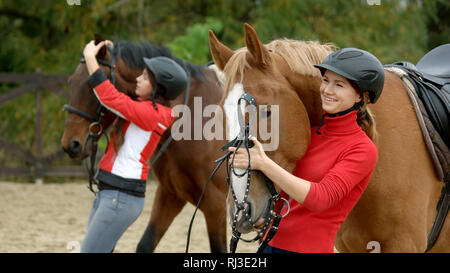 Bella ragazza sorridente che abbraccia il suo cavallo al ranch. Foto Stock