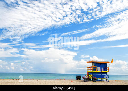 South Beach, Miami, Florida, bagnino casa in un colorato stile Art Deco su nuvoloso cielo blu e Oceano Atlantico in background, famosa in tutto il mondo percorso di viaggio Foto Stock