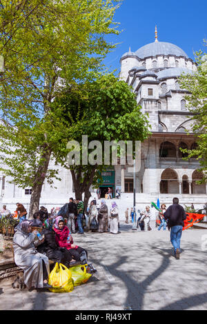 Istanbul, Turchia : persone sedersi al di fuori della nuova moschea (Yeni Camii) costruita tra il 1660 e il 1665, un Ottoman Imperial moschea nel quartiere Eminönü, su t Foto Stock