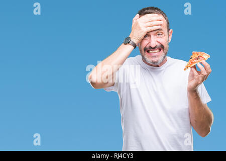 La mezza età annoso senior uomo mangiare la pizza slice su sfondo isolato ha sottolineato con la mano sulla testa, sconvolto con vergogna e la sorpresa di fronte, arrabbiato e fr Foto Stock