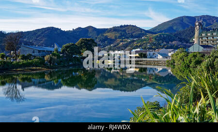 Panorama della città di Nelson, che si riflette nelle acque tranquille del fiume Maitai, Nuova Zelanda. Foto Stock