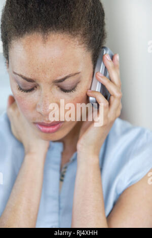 Junge Frau telefoniert mit Mobiltelefon, Blick nach unten Foto Stock