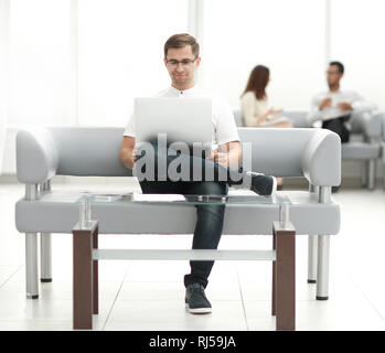 Uomo d affari con computer portatile seduti nella hall dell'hotel . Foto Stock