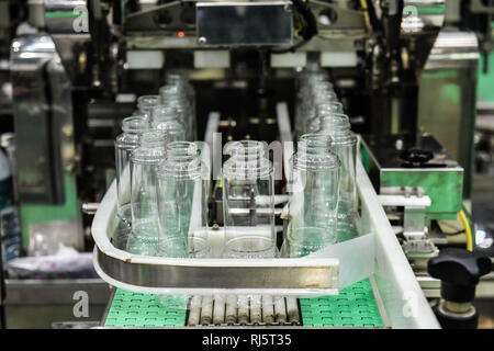 Cancellare le bottiglie di vetro trasferimento sul trasportatore automatizzato di sistemi di automazione industriale per il pacchetto Foto Stock