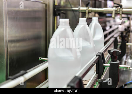 Bianco di bottiglie di plastica trasferire sul trasportatore automatizzato di sistemi di automazione industriale per il pacchetto Foto Stock