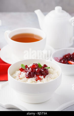 Farinata di Riso o budino caramellato con mirtilli rossi e menta fresca. Una sana colazione vegetariana concetto. Foto Stock