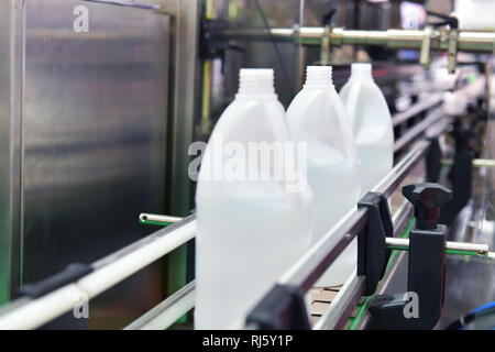 Bianco di bottiglie di plastica trasferire sul trasportatore automatizzato di sistemi di automazione industriale per il pacchetto Foto Stock