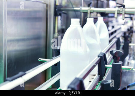 Bianco di bottiglie di plastica trasferire sul trasportatore automatizzato di sistemi di automazione industriale per il pacchetto Foto Stock