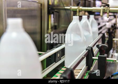 Bianco di bottiglie di plastica trasferire sul trasportatore automatizzato di sistemi di automazione industriale per il pacchetto Foto Stock