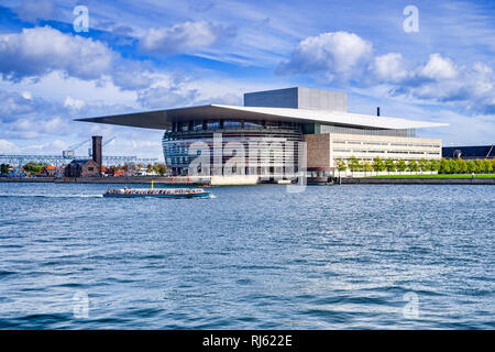 23 Settembre 2018: Copenhagen, Danimarca - Copenhagen Opera House o Operaen, su Holmen Island, con una imbarcazione turistica passando sul porto. Foto Stock