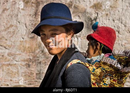 Il Tibet, das Kloster Drepung, Frau trägt tipo auf dem Rücken Foto Stock