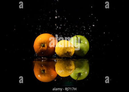 Apple,arancio e limone stand su sfondo nero Foto Stock