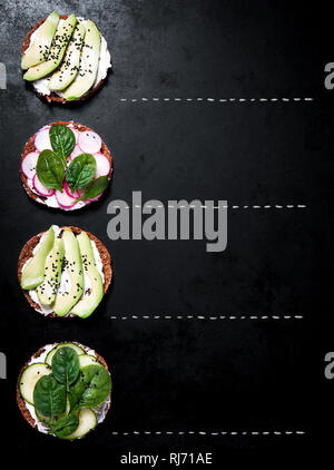 Varie sano Vegetariano o Vegano panini con diversi ortaggi su uno sfondo scuro, vista dall'alto. Vita sana nozione Foto Stock