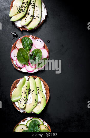 Varie sano Vegetariano o Vegano panini con diversi ortaggi su uno sfondo scuro, vista dall'alto. Vita sana nozione Foto Stock