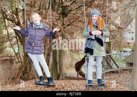 Zwei Kinder auf Schaukel im Garten Foto Stock