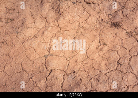 Vista dall'alto in basso di un terreno argilloso incrinato secco durante la stagione della siccità nel deserto Foto Stock