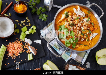 Vista aerea di sostanziosi Mulligatawny minestra in una casseruola di metallo su un tavoli in legno nero con un mestolo e ingredienti, tradizionale Indiana e engl Foto Stock