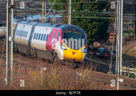 Virgin Pendolino treno elettrico che mostra la capacità di inclinazione. Visto alla giunzione Winwick sulla linea principale della costa occidentale. Foto Stock