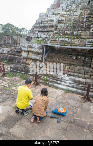 Siem Reap, Angkor, Tempel Baphuon, ein paar kambodschanisches beim beten auf dem Tempeldach Foto Stock