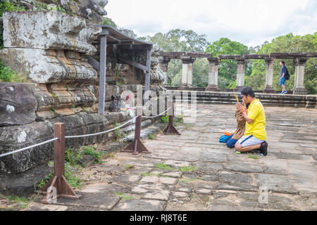 Siem Reap, Angkor, Tempel Baphuon, ein paar kambodschanisches beim beten auf dem Tempeldach Foto Stock