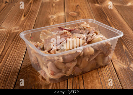 Vista laterale della scatola di shredded pollo lesso sulla tavola di legno Foto Stock