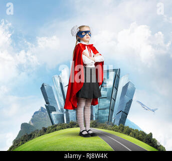 Girl power concetto con cute kid custode contro il paesaggio sullo sfondo Foto Stock