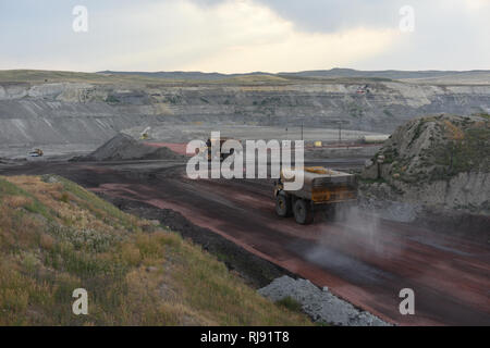 Grandi camion acqua spruzzare acqua sulle strade per il controllo delle polveri, fossa aperta le miniere di carbone in polvere, Bacino del fiume del Wyoming Foto Stock