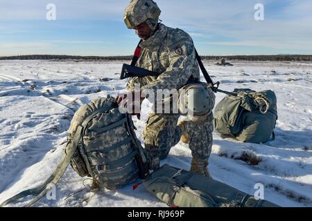 Stati Uniti Il personale dell'esercito Sgt. Kofi Latiff, nativo di Brooklyn, NY, assegnato alla società B, 6° Brigata Battaglione ingegnere (airborne), quarta brigata di fanteria combattere Team (airborne), XXV divisione di fanteria, U.S. Esercito di Alaska, fissa il suo zaino dopo un training airborne saltare da un CH-47 elicottero Chinook Malemute sulla zona di caduta sulla giunzione base Elmendorf-Richardson, Alaska, giovedì, nov. 3, 2016. I soldati del 4/25 IBCT appartengono al solo American airborne brigade nel Pacifico e sono addestrati per eseguire le manovre di volo in condizioni di freddo intenso/ambienti ad altitudini elevate a sostegno della lotta contro il partner Foto Stock