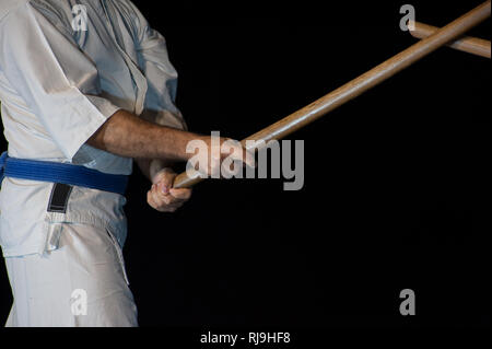 Aikido fighter con il suo bastone di legno durante un combattimento Foto Stock