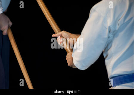 Aikido fighter con il suo bastone di legno durante un combattimento Foto Stock