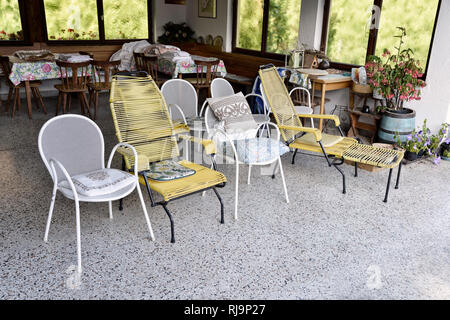 Alte Gartenstühle auf einer überdachten Terrasse, Foto Stock