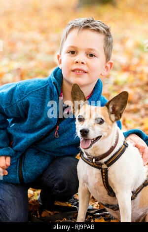 Junge mit hund, im Herbstlaub, Parco, Herbstausflug, Herbsttag, Herbstspaziergang, Foto Stock