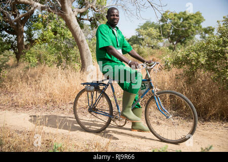 Villaggio Bissiga, Yako, Burkina Faso, 29 novembre 2016; Yourouaogo Ouedraogo, guardia forestale, con bike fornite da aiuto ad albero. Foto Stock