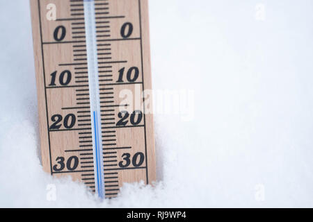 Termometro in legno nella neve con temperatura di congelamento spazio copia Foto Stock