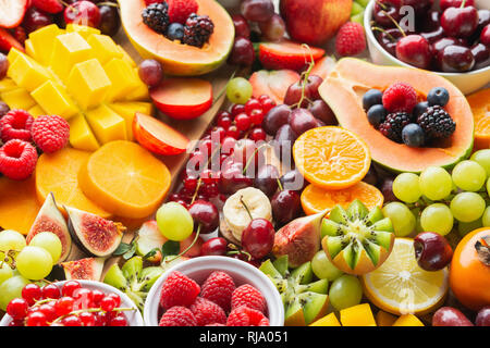 Taglio Sano frutta sfondo, Fragole Lamponi arance Prugne Mele Kiwi uva ribes rosso mirtilli persimmon mango Foto Stock