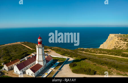 Antenna; drone vista del bianco-rosso faro Cabo Espichel sul bordo della terra; acque turchesi dell'Oceano Atlantico allungamento all' orizzonte; bella Foto Stock